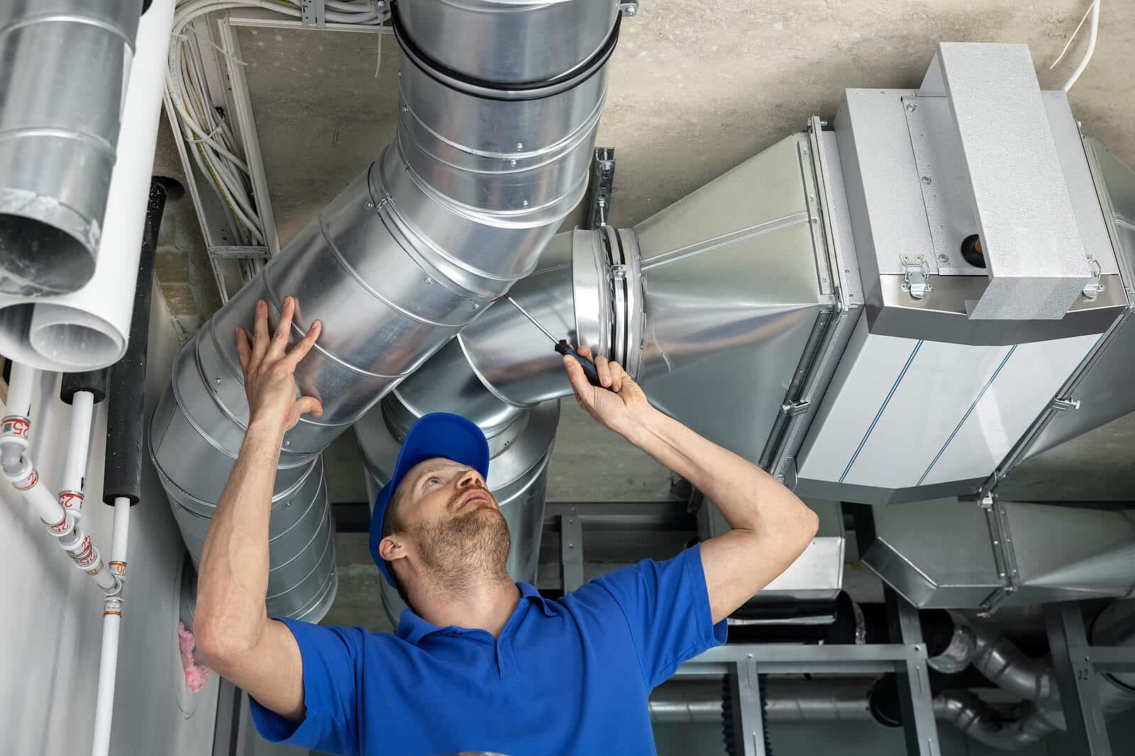 HVAC technician inspecting and repairing air ducts in Manteca