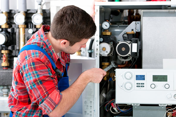 Heating technician repairing boiler controls in Manteca