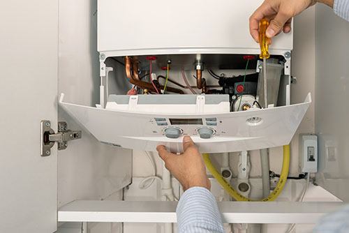 Heating technician repairing a residential boiler in Manteca