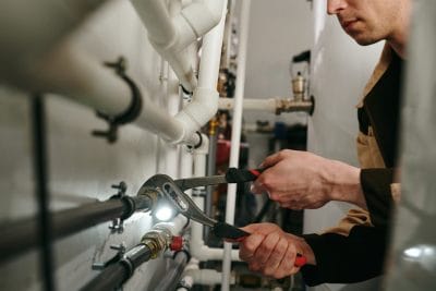 Technician inspecting commercial plumbing pipes in Manteca
