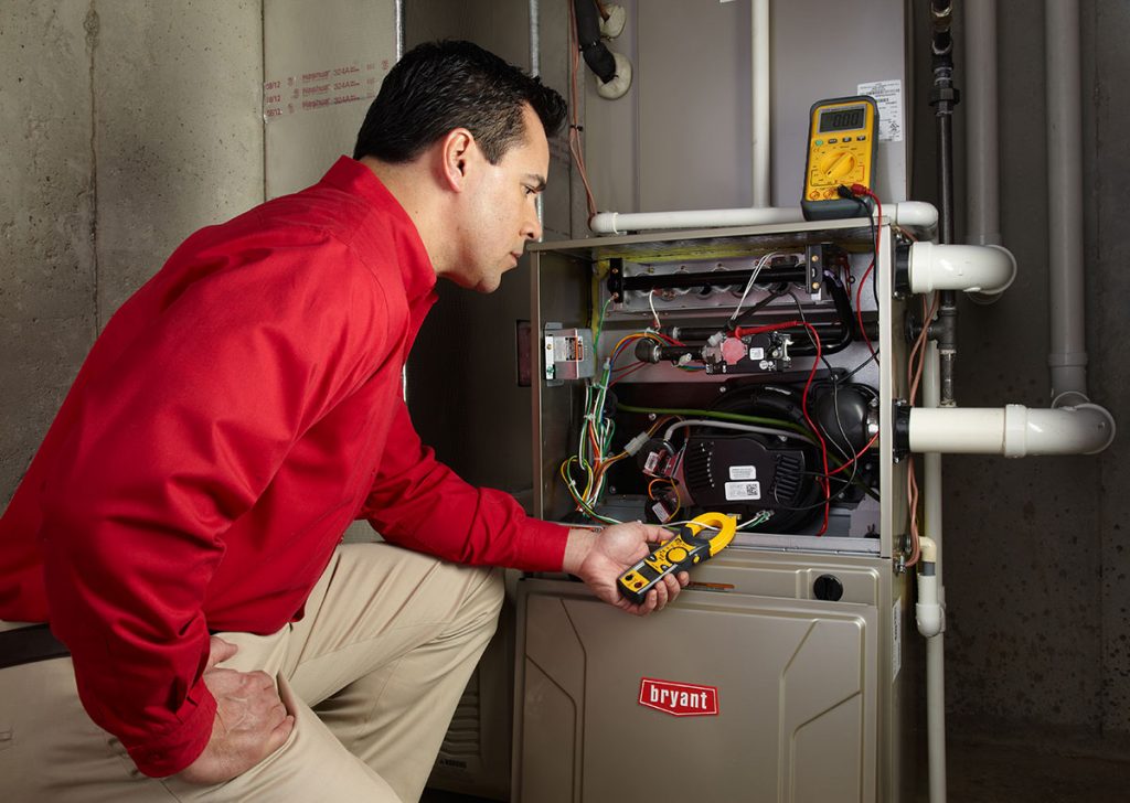 Heating technician diagnosing a furnace repair in Manteca