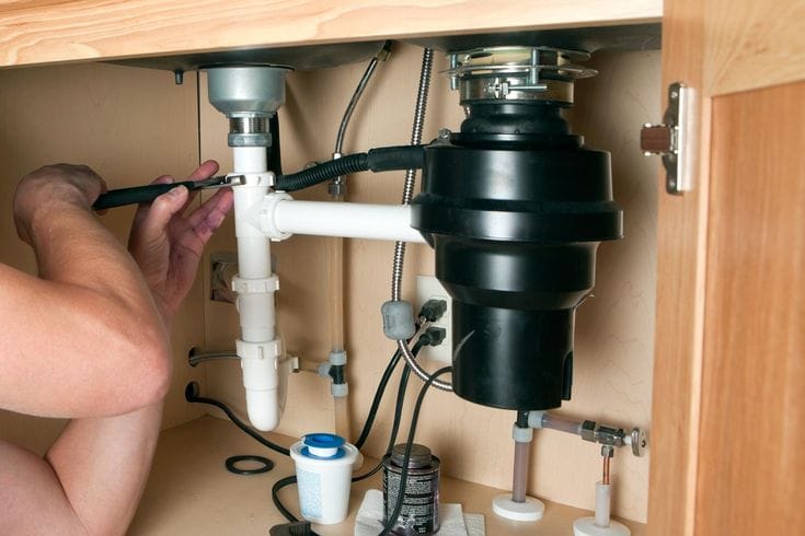 Plumber repairing a garbage disposal in Manteca