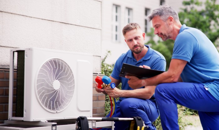HVAC technicians installing an outdoor air conditioning unit in Manteca