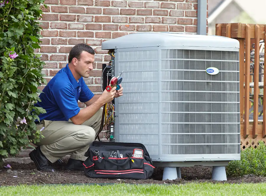 HVAC technician inspecting an outdoor AC unit in Manteca