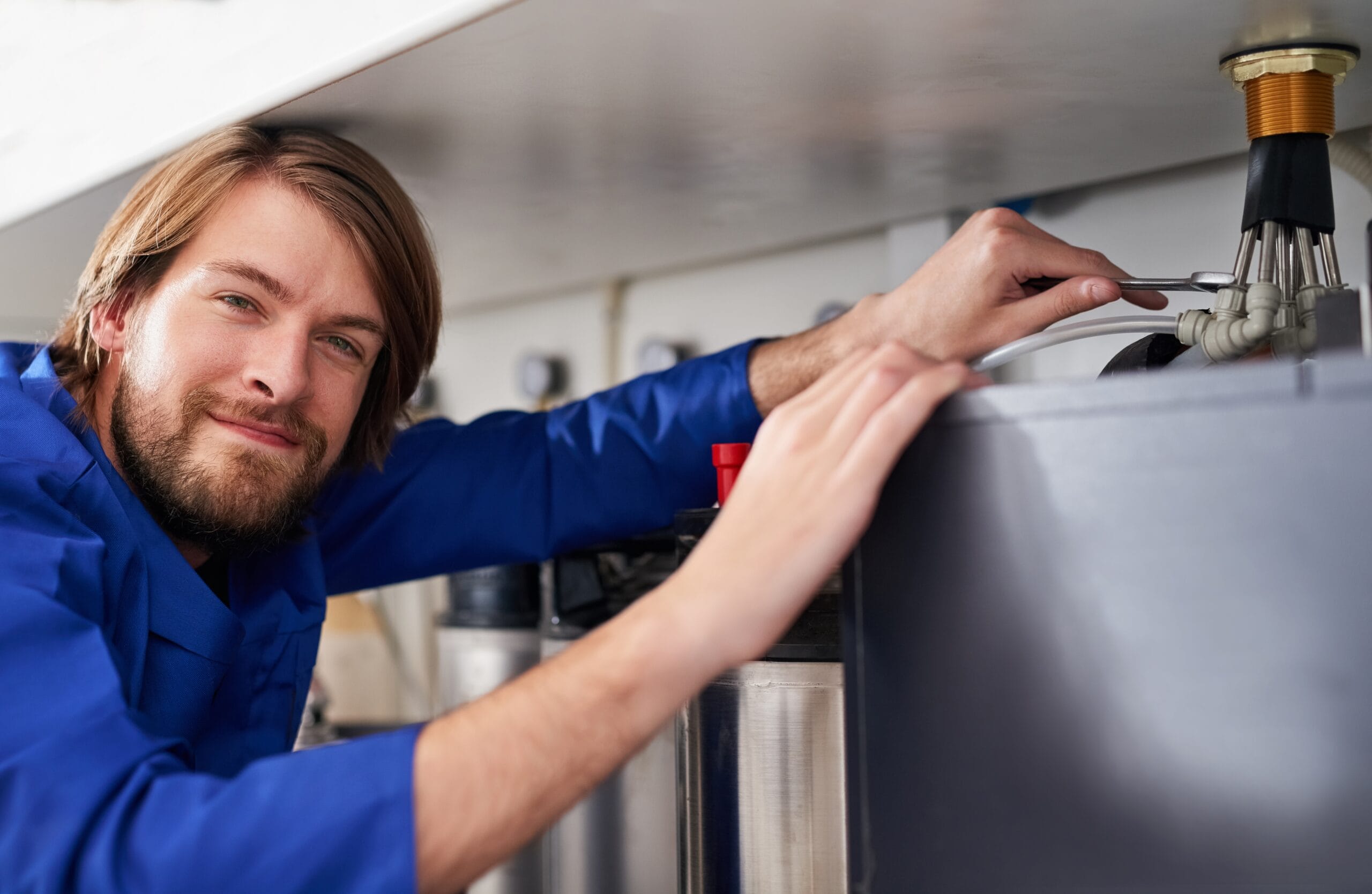 Technician servicing a residential water heater tank in Manteca